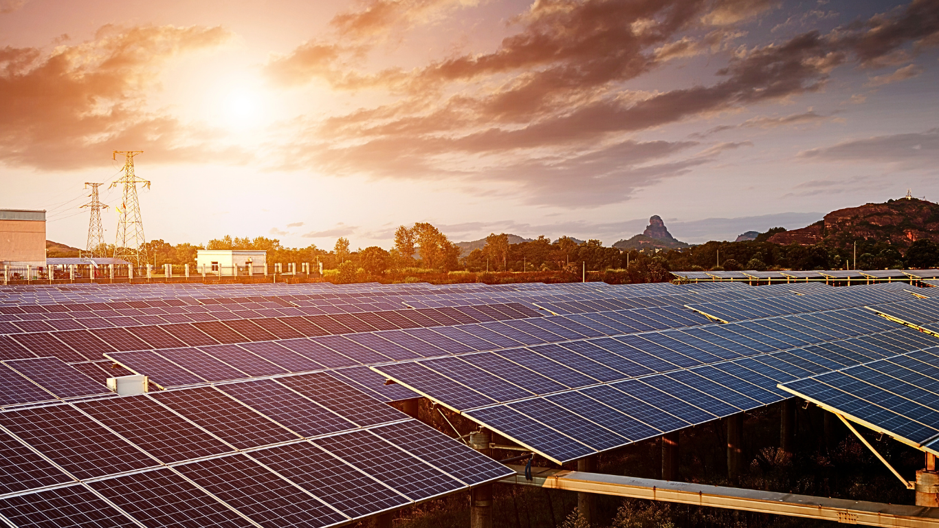 Große Agri-PV-Anlage mit Solarmodulen unter klarem Himmel und Umgebungslandschaft im Hintergrund